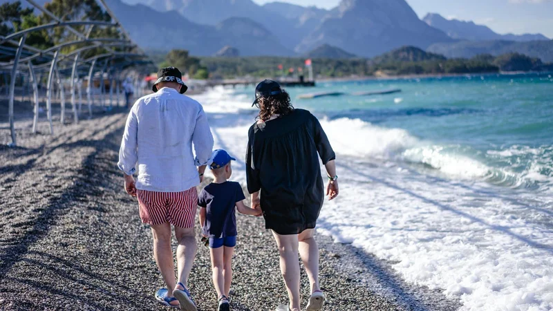 Familie am Mittelmeer-Strand mit Bergen im Hintergrund