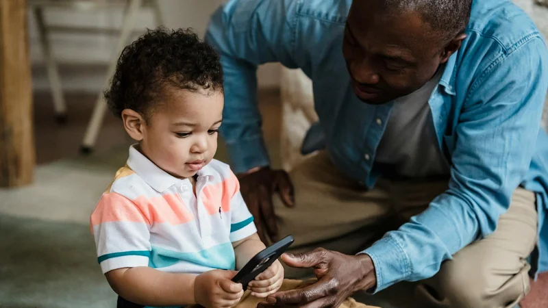 Vater und Sohn beschäftigen sich gemeinsam mit einem Smartphone