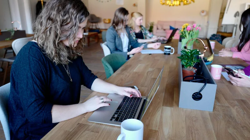 Frauen arbeiten im modernen Coworking-Space mit Laptops